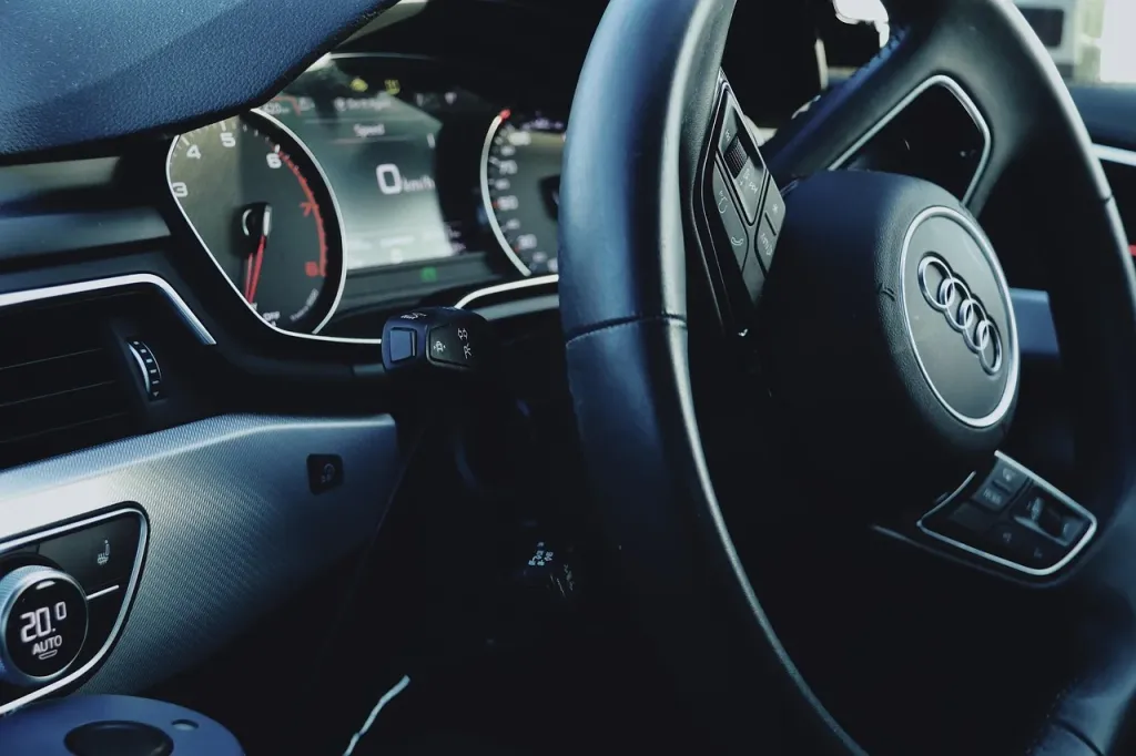 Zbliżenie na komorę silnika Audi A4 B7 z widocznymi podzespołami mechanicznymi i instalacją elektryczną.