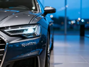 Srebrny Mercedes GLK X204 zaparkowany na tle nowoczesnego budynku w świetle zachodzącego słońca.