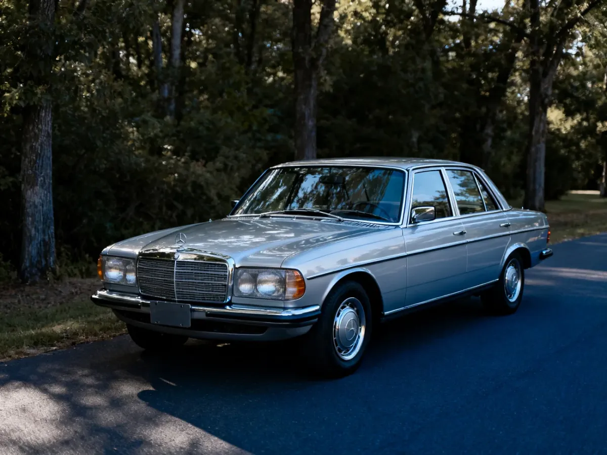 Klasyczne coupé Mercedes-Benz W114 na tle spokojnej, zadrzewionej drogi
