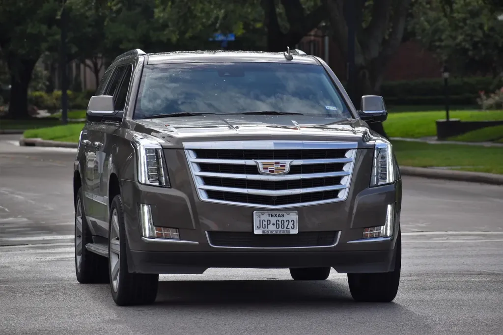 Luksusowy SUV Cadillac Escalade zaparkowany na zewnątrz, prezentujący nowoczesny design i prestiżowy charakter pojazdu.