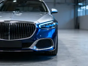 Srebrny Mercedes-Benz GLA zaparkowany na tle nowoczesnej architektury w świetle zachodzącego słońca.